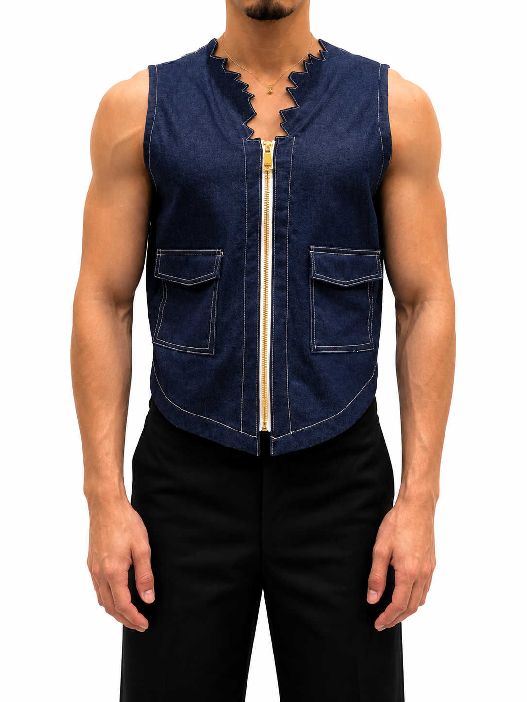 A man wearing a sleeveless dark blue denim vest with a scalloped neckline, a front zipper, and two front flap pockets, paired with black pants against a white background.